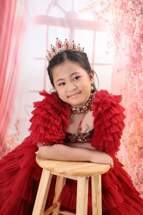 Kylie Rose resting on a wooden stool, wearing her tiara